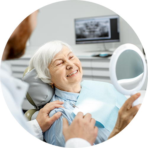 Senior dental patient admiring her smile in a mirror