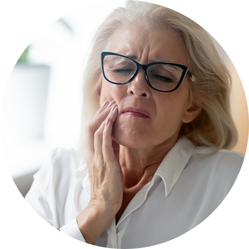 Senior woman holding the side of her face in pain