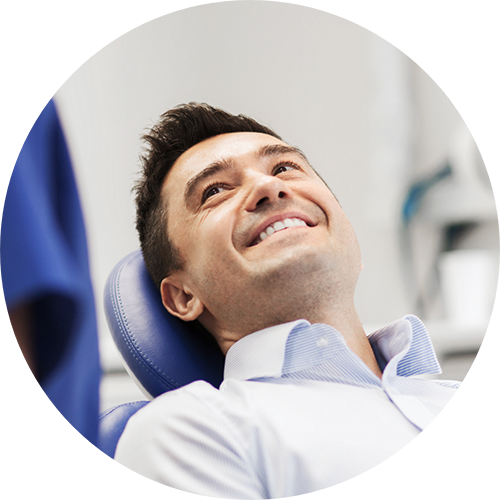 Smiling man in the dental chair looking up at his dentist