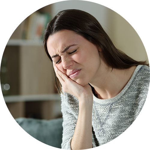 Woman holding her cheek in pain before seeing an emergency dentist in Las Vegas